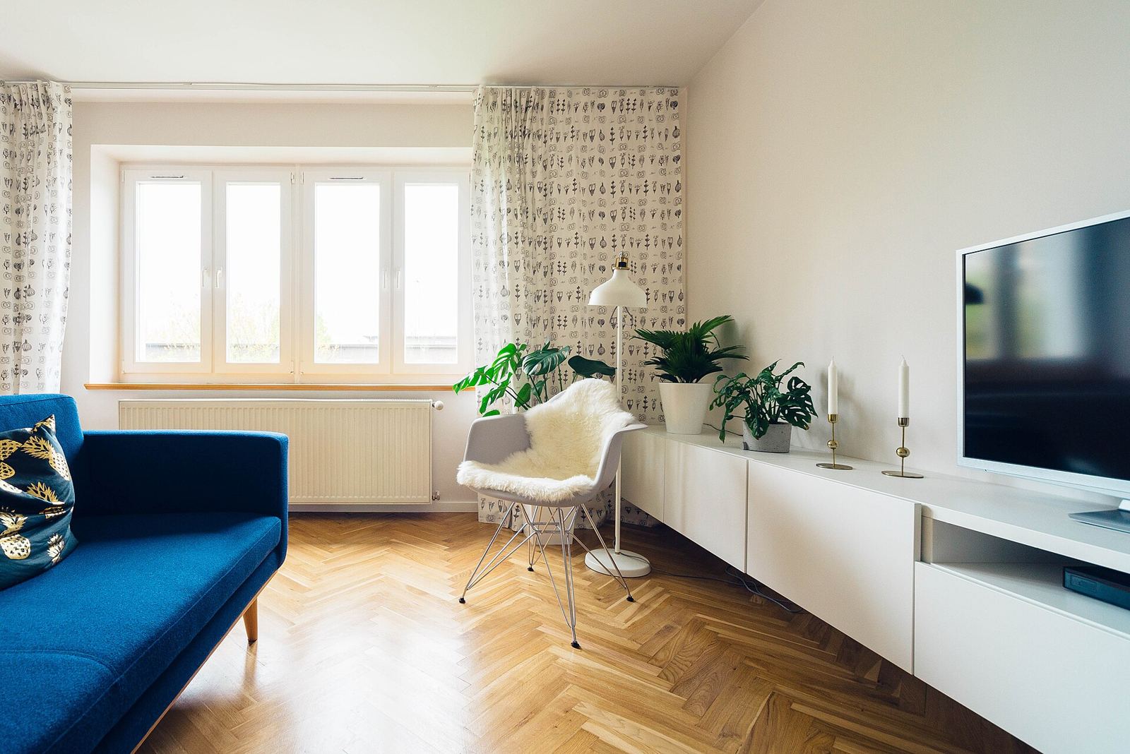 A bright staged living room with wood floors
